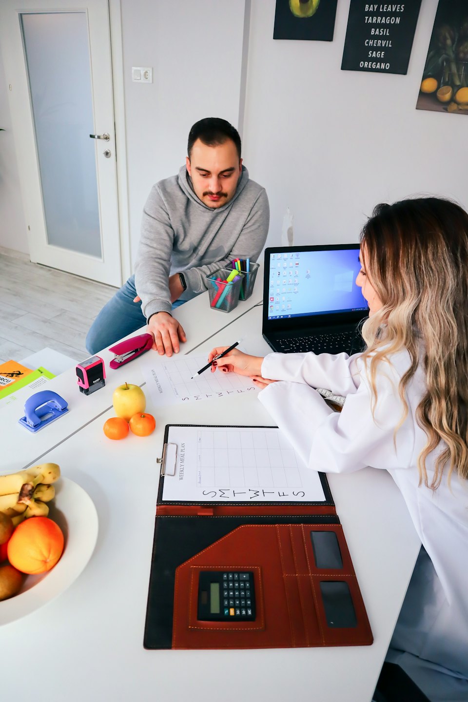 Nutritionist discusses meal plan with client in consultation room.